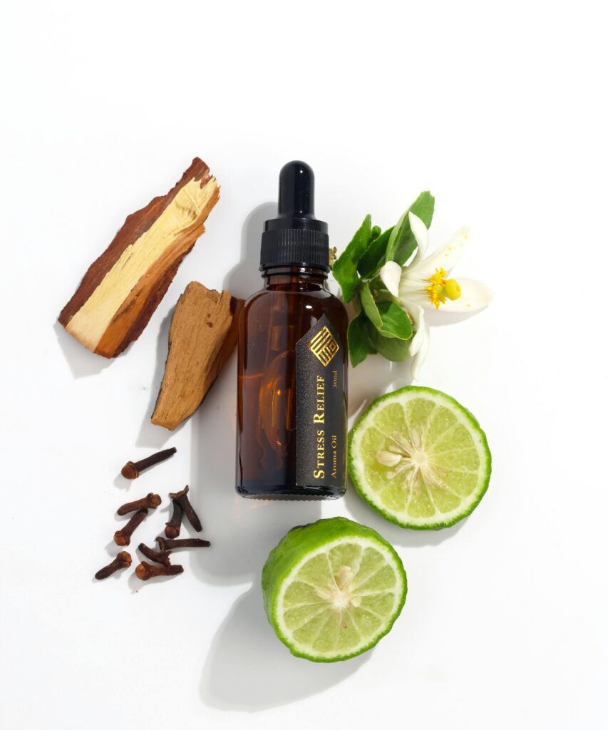 pexels photo 18680598 18680598 Flat lay of essential oil bottle with citrus, cloves, and wood for aromatherapy.